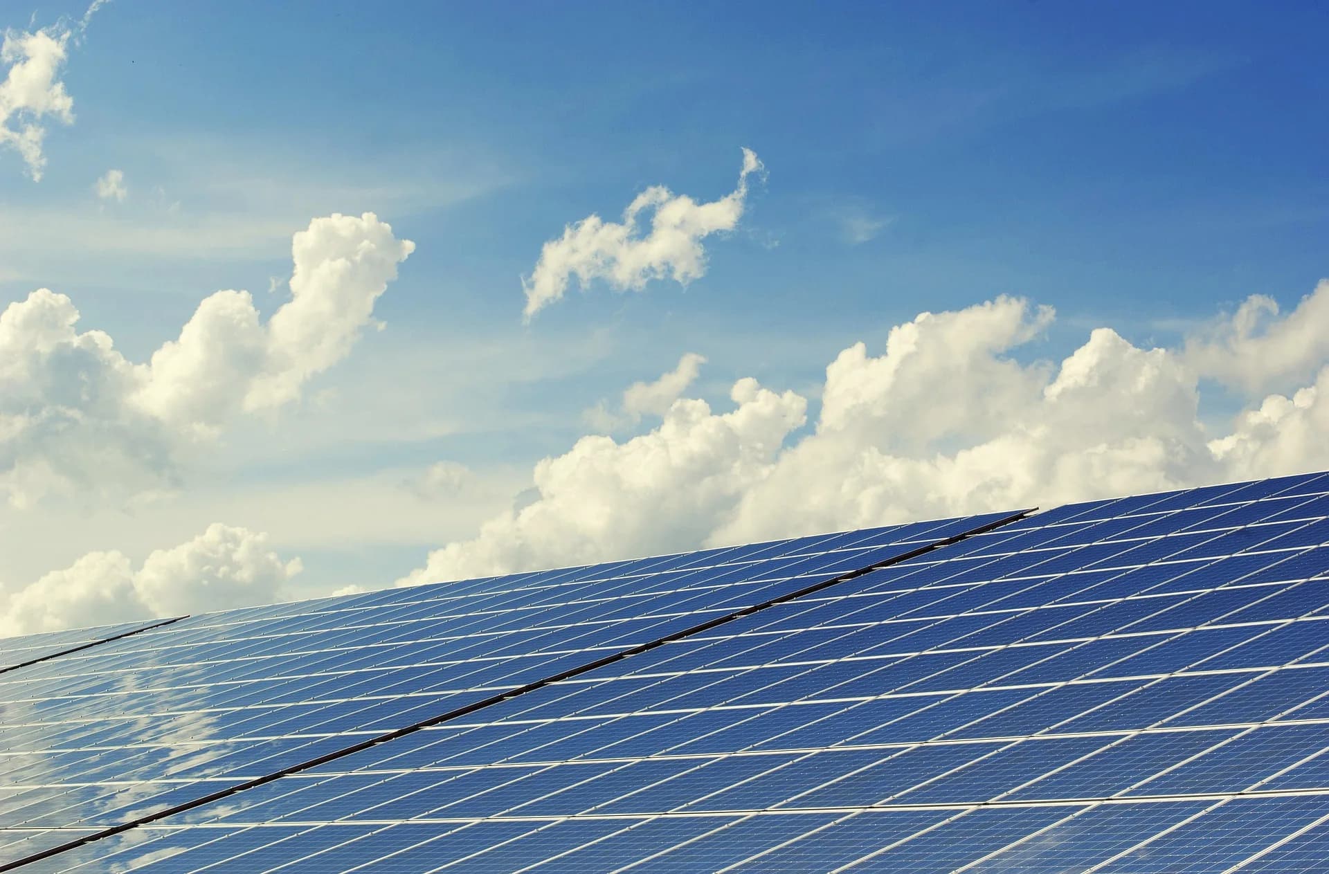 Arreglo de paneles solares fotovoltaicos bajo un cielo con nubes